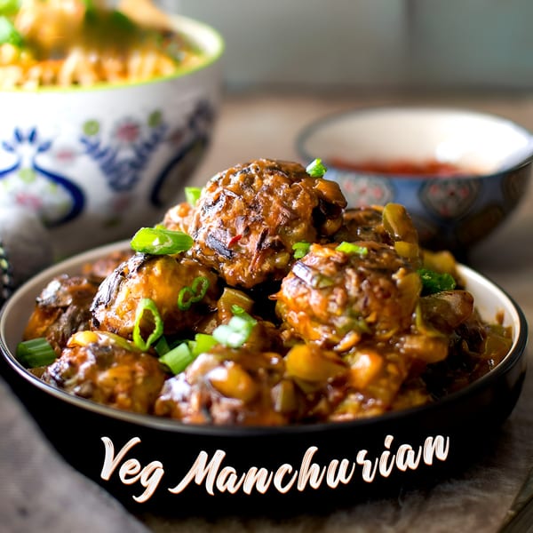 Veg Manchurian, an Indian dish, in a black bowl, garnished with green onions.